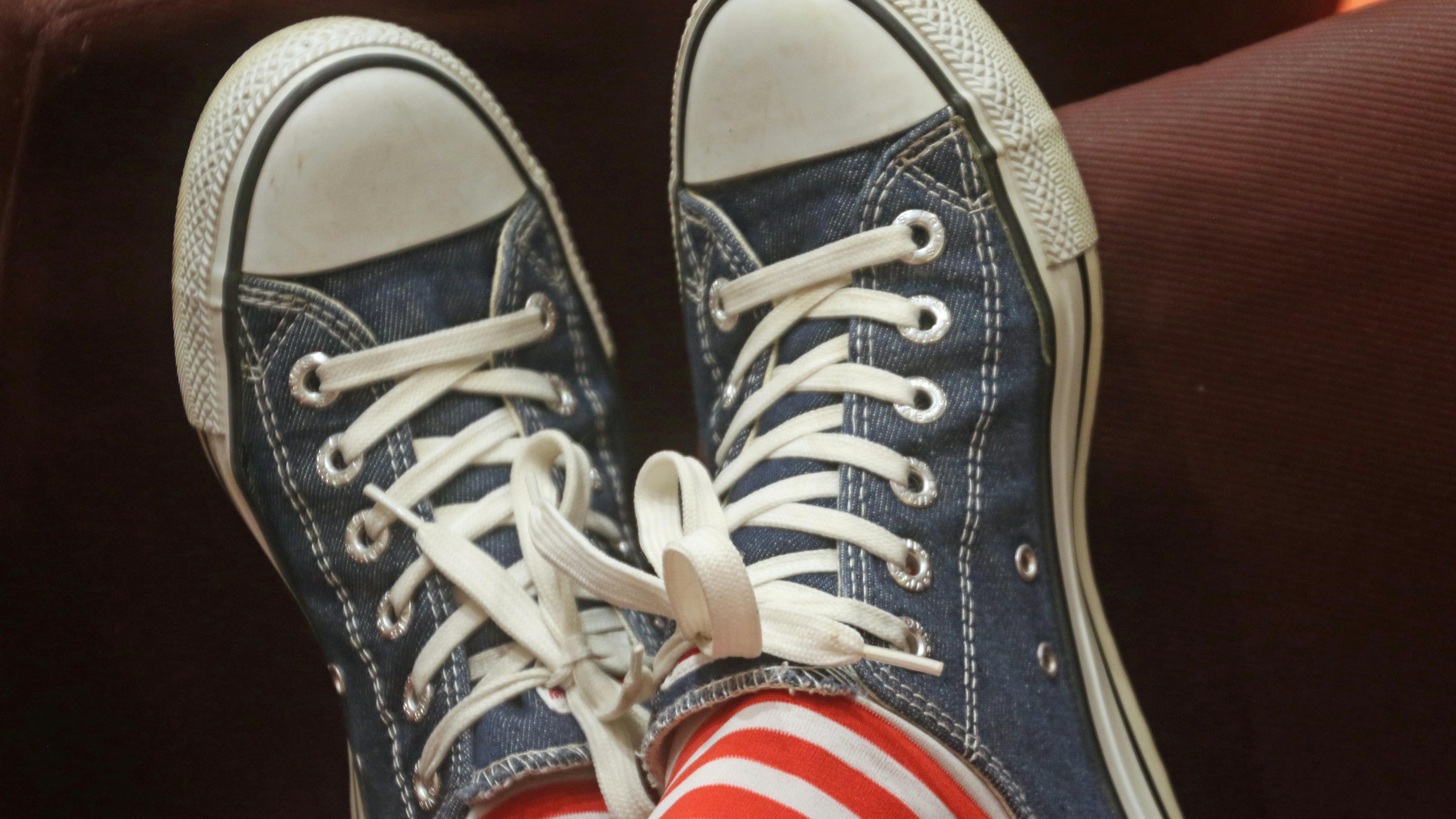 Bare feet under desk, no-shoes office policy in modern workspace.