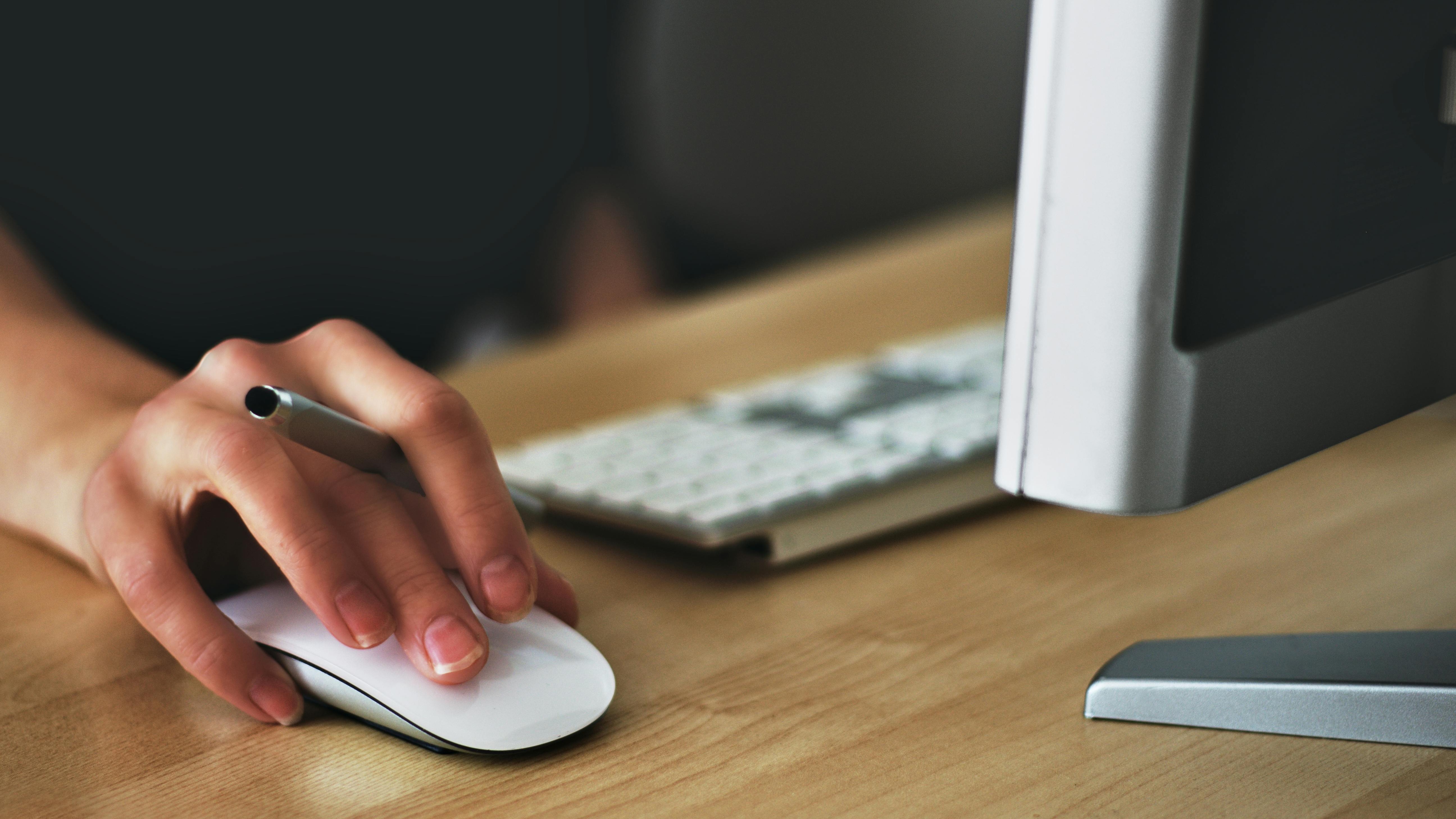 Hand using a mouse with laptop, ISP throttling detection, close-up.