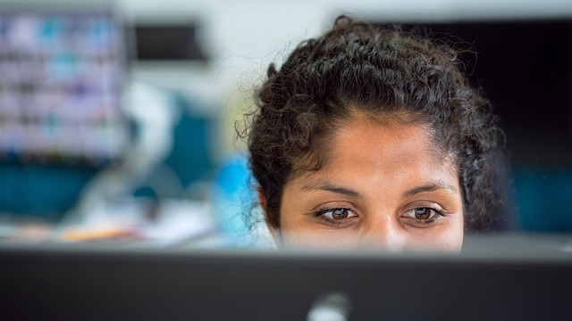 Confident professional woman smiling in corporate portrait, talent loss in AI era.
