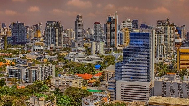 Early retirement in Thailand: Enjoying coffee on a balcony with city view.
