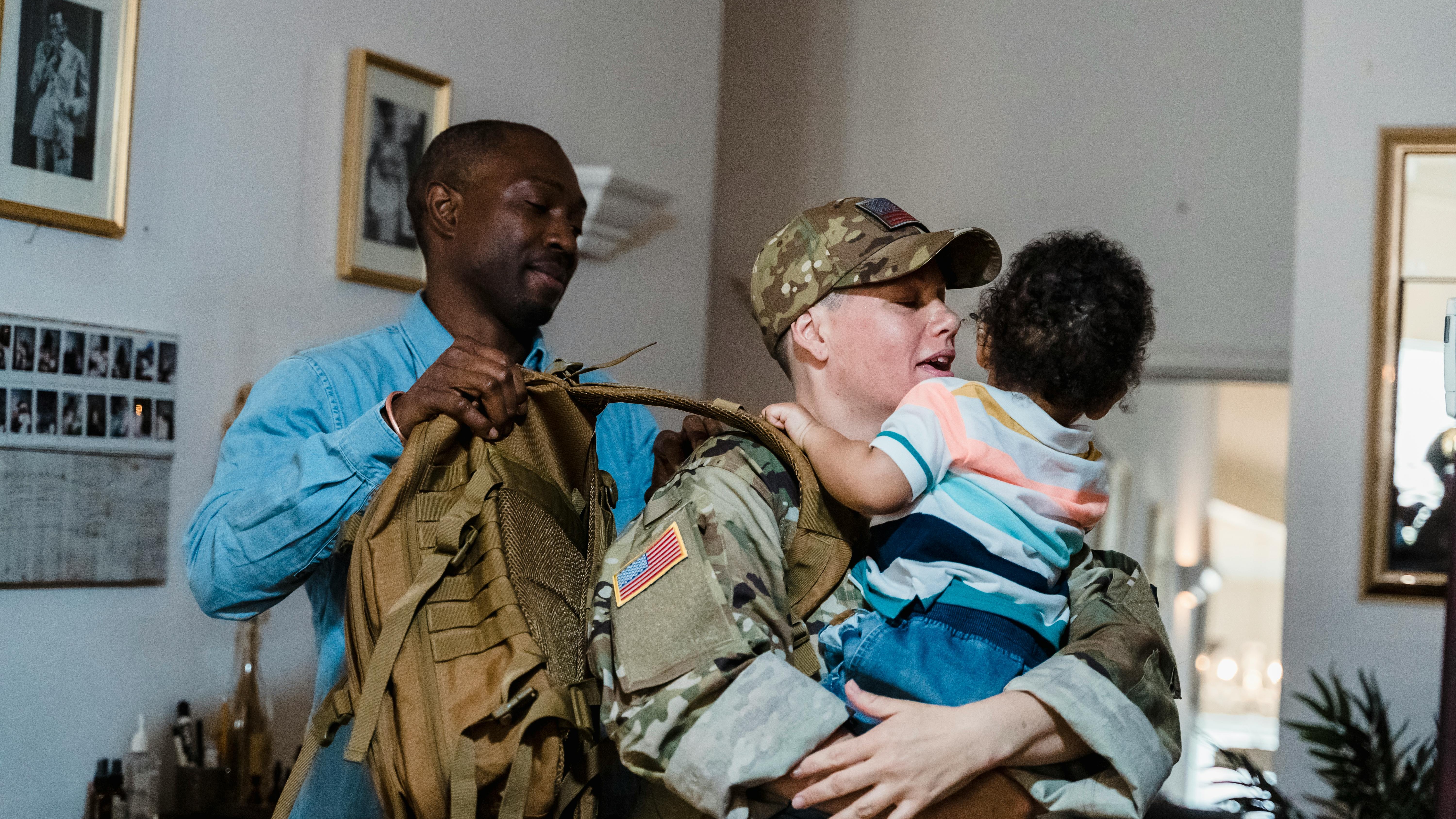 Happy military couple, USO programs for military spouses, embracing outdoors.