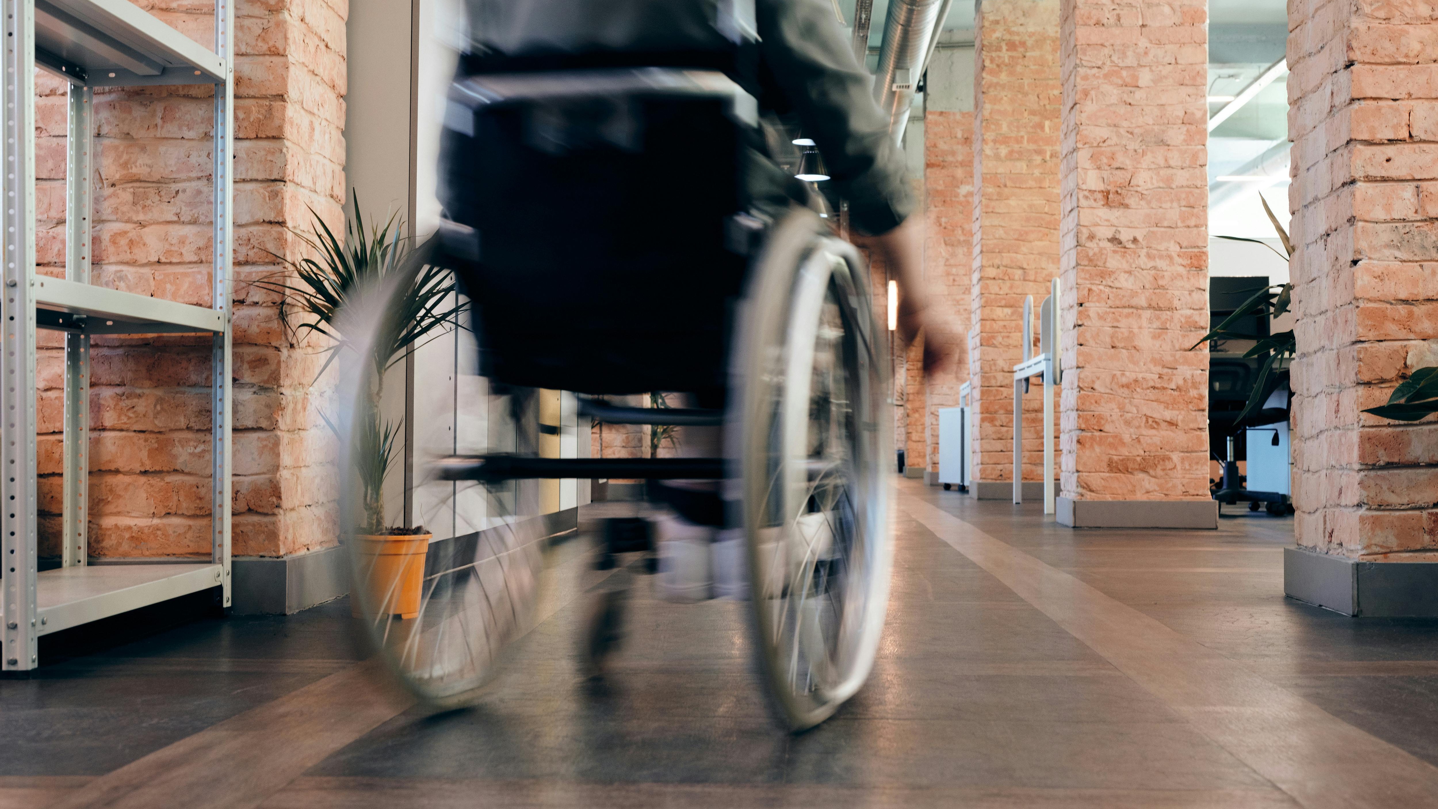 Hands in unity around disability symbol, disability-inclusive employment.