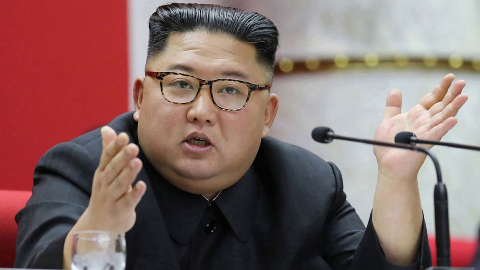 North Korean leader speaking at podium, formal setting.