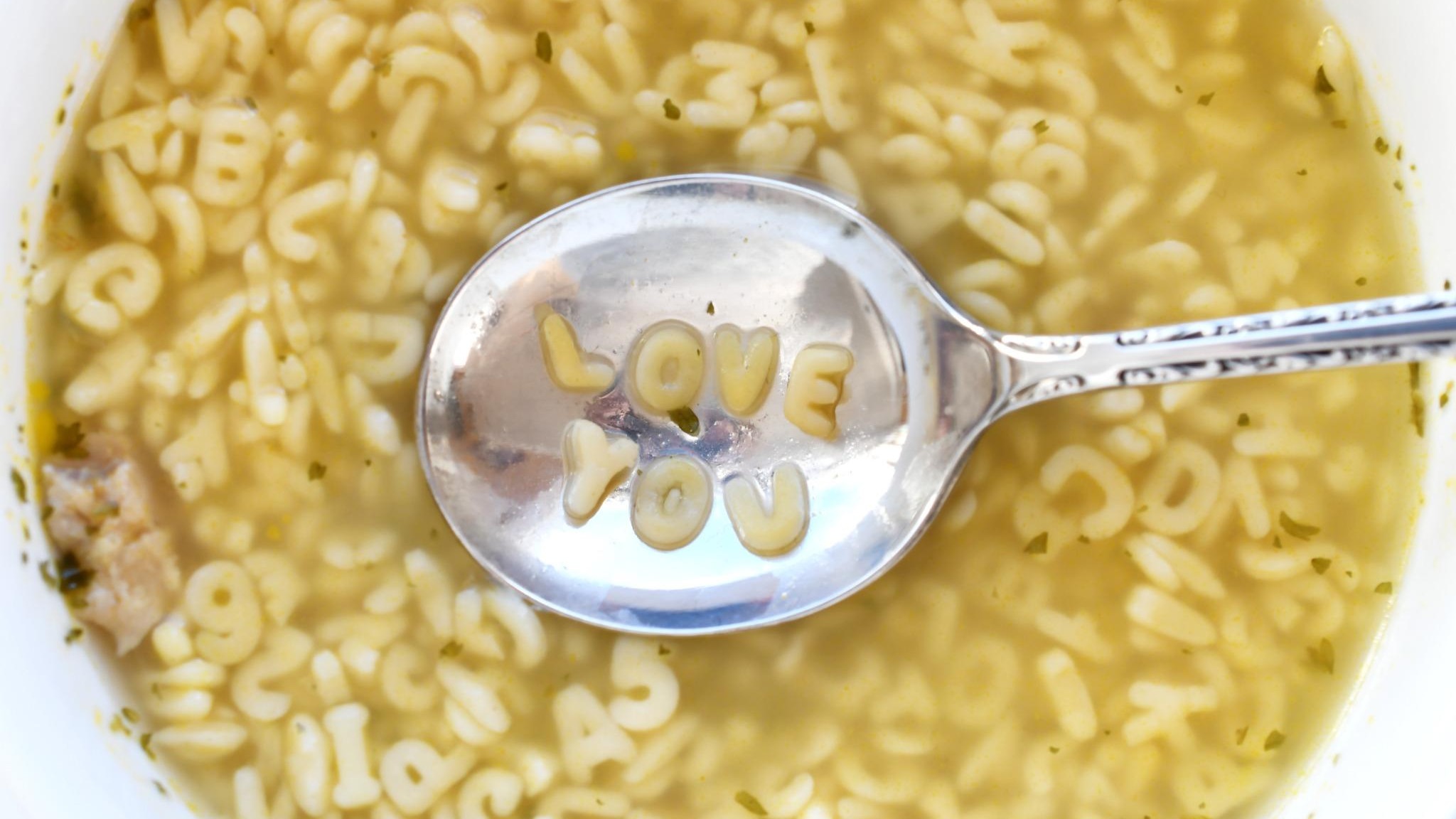 Easy alphabet soup recipe for kids with peas and carrots in blue bowl.