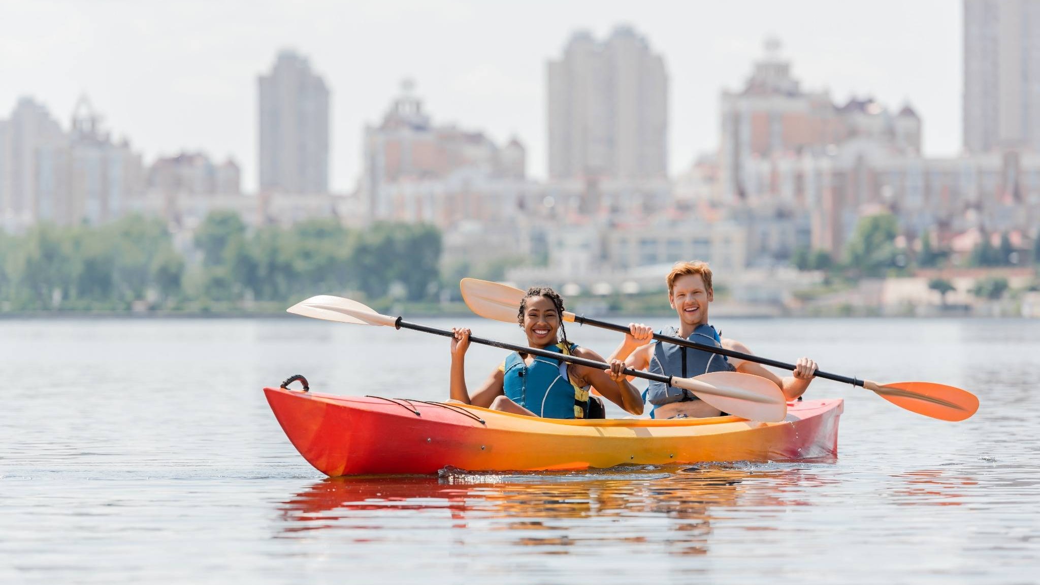 Happy couple kayaking together, embracing adventure, ideal for retirement planning for parents.
