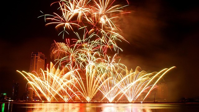 Discarded fireworks emphasize environmental impact on sidewalk.