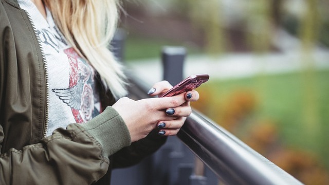 Woman engaging in milspouse group chat, typing on laptop.