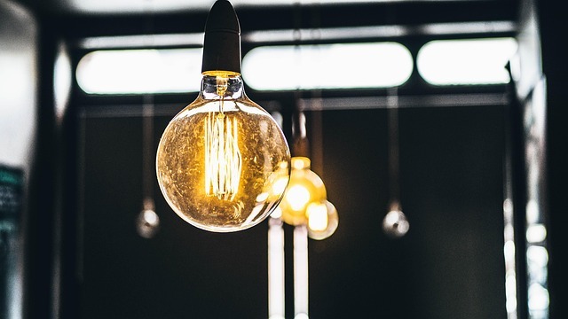 Yellow light bulb caught in a white loop, symbolizing hurdles to innovation.