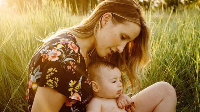 Mother feeding baby, emphasizing postpartum self-care with nurturing scene.