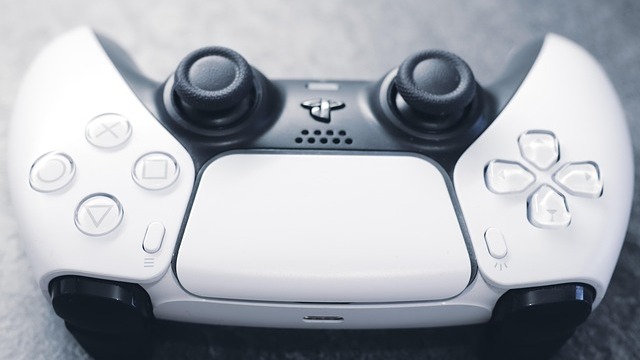 PS5 gaming accessories with controller, SSD, remote on blue background.