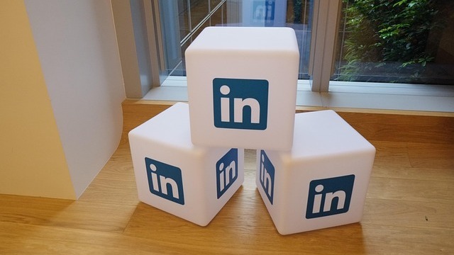 AI in recruiting: Man near LinkedIn building, showcasing urban reflections.