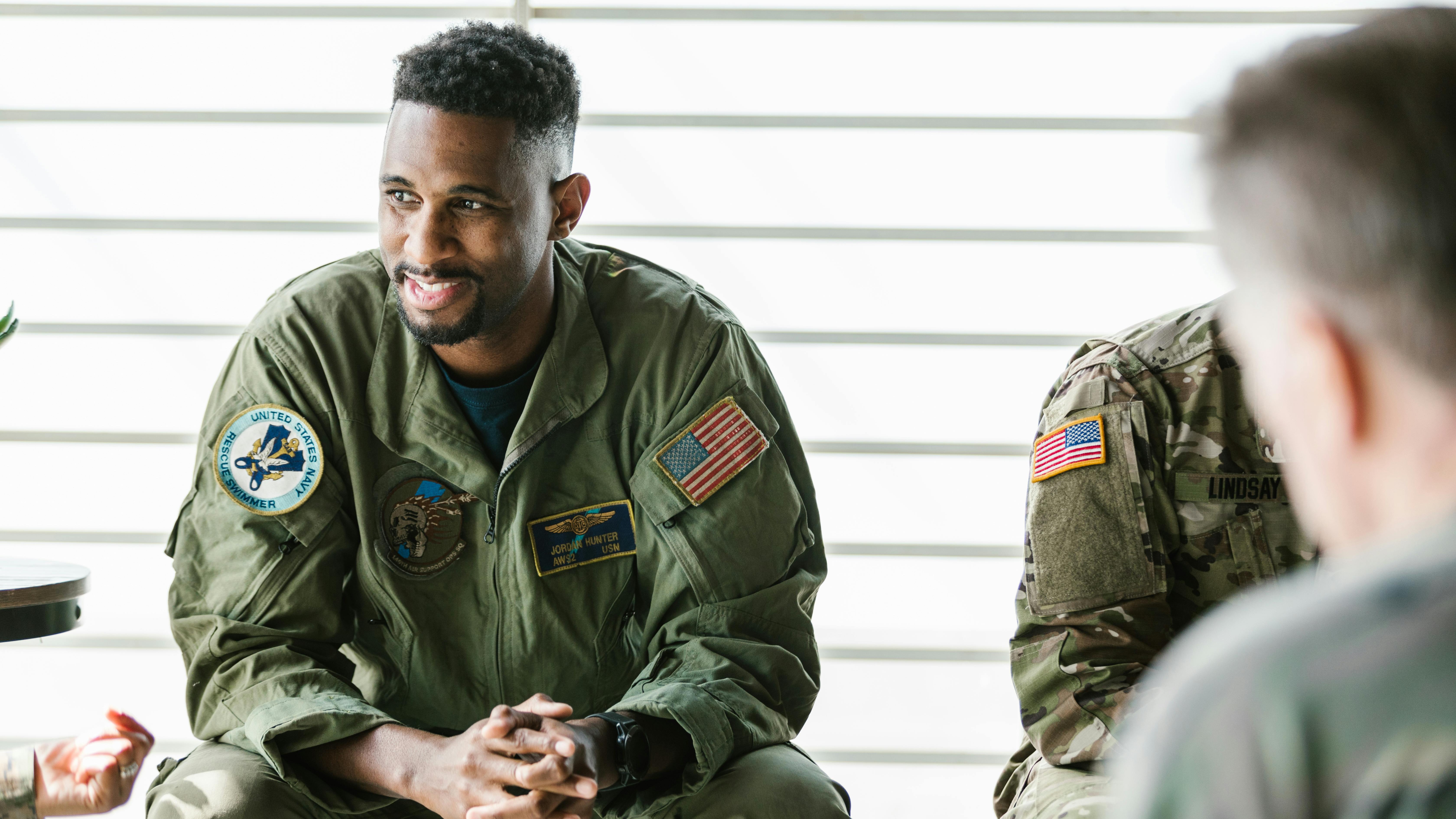 Veterans engaging in discussion in a modern office for National Hire a Veteran Day.