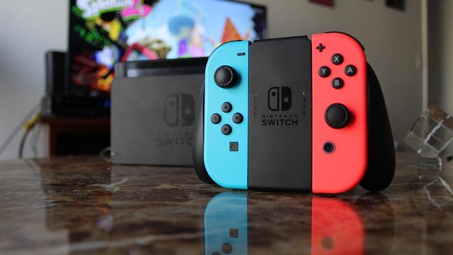 Close-up of hands holding a Nintendo Switch 2 console for user experience survey.