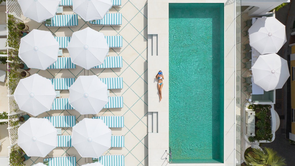 Luxurious Mediterranean hotel with pool and patio, new luxury hotel opening.
