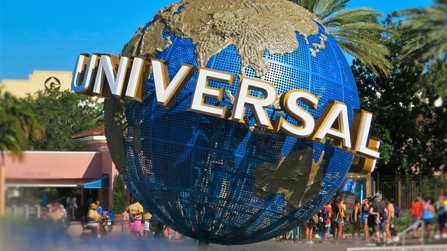 Epic Universe theme park grand hotel exterior with gardens and fountain
