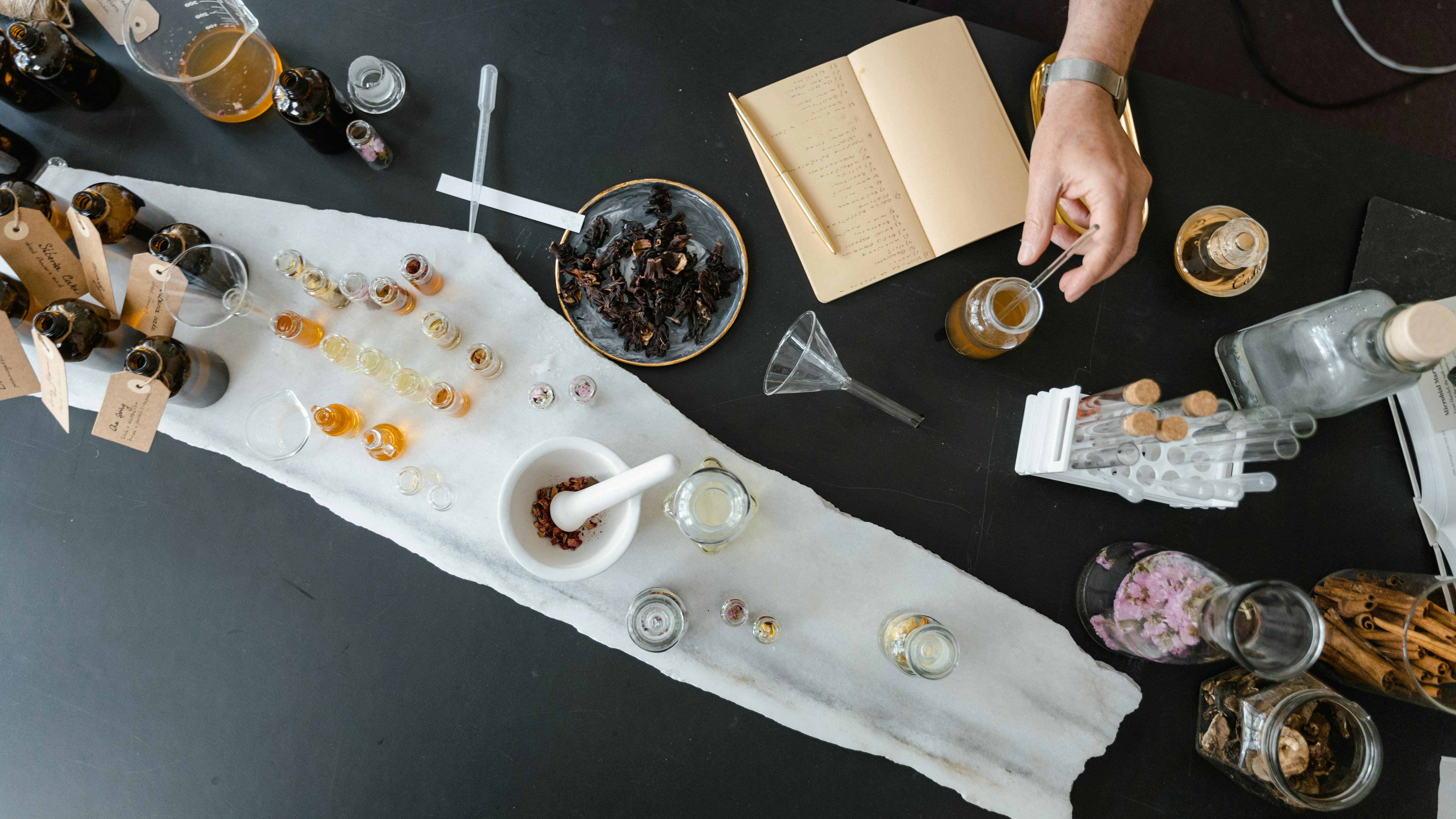 Hands preparing essential oils on rustic table for personalized luxury Mother's Day experiences.