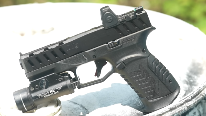 Dura DY9 Island review with handgun and scenic tropical backdrop.