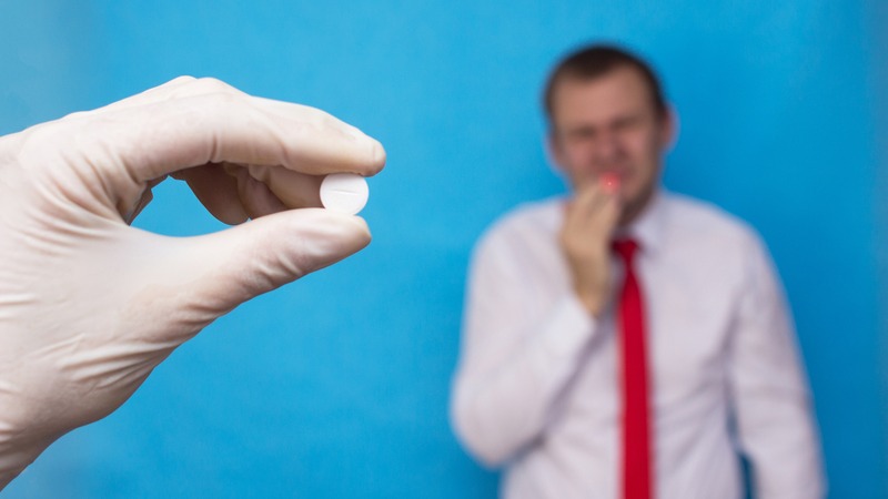 person holding an anti-viral drug in front of another person