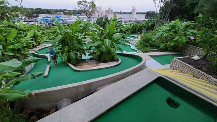 Families enjoying mini golf at Cool Crest with art deco course and neon balls