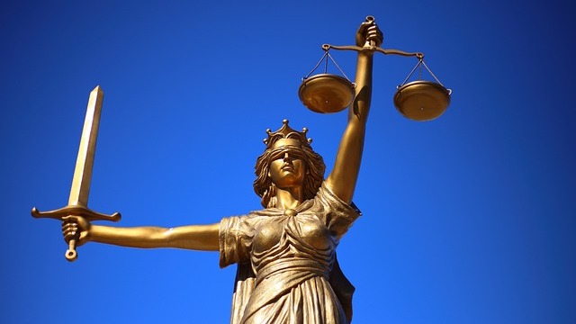 Courtroom scene with scales of justice and gavel on table
