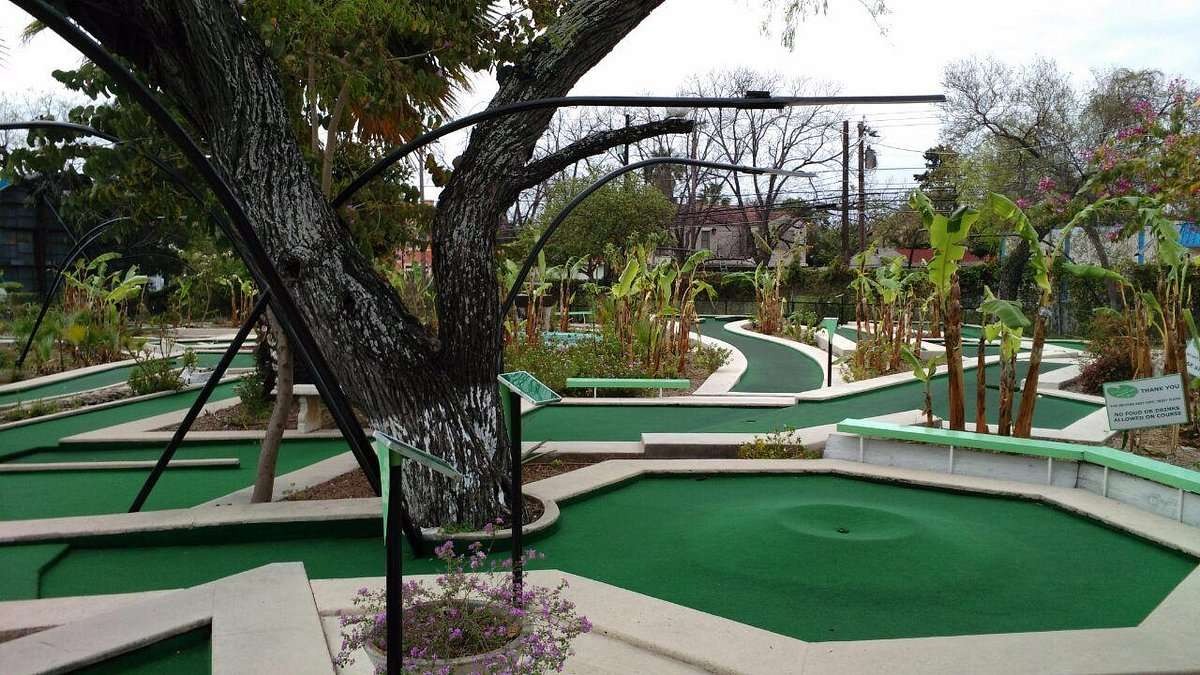 Golden hour mini golf at Cool Crest, family playing under art deco lights