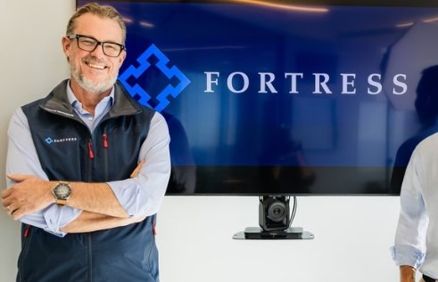 Fortress co-CEO stands confidently inside modern office.