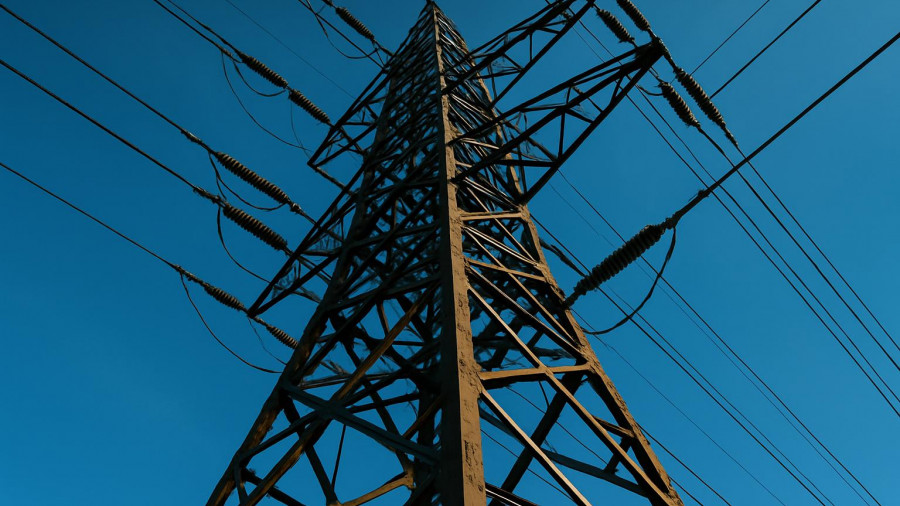 Electricity pylon against blue sky for PJM winter outlook power supplies.