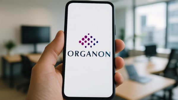 Organon logo on smartphone in an office setting.