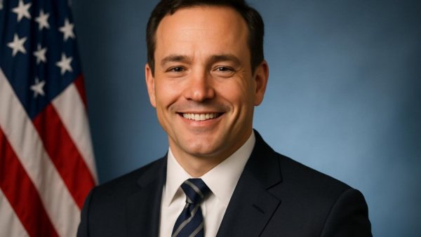 Professional portrait of a smiling man with American flag, lowering costs for North Jersey families.