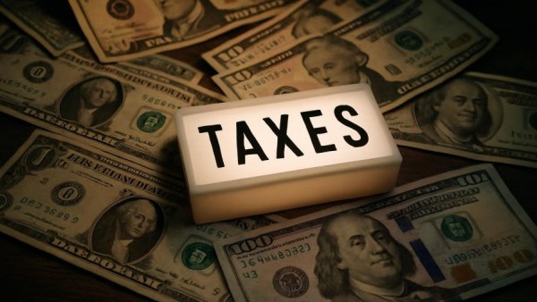 US dollar bills with 'TAXES' sign, symbolizing New Jersey revenue collections.