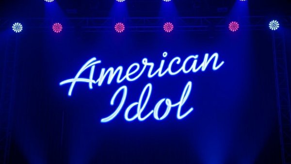 American Idol logo illuminated in blue neon light.