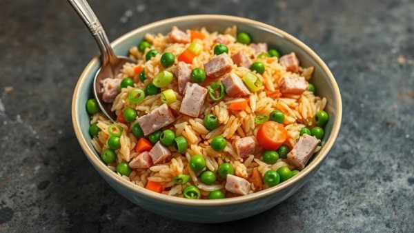Delicious leftover ham fried rice with veggies in a white bowl.