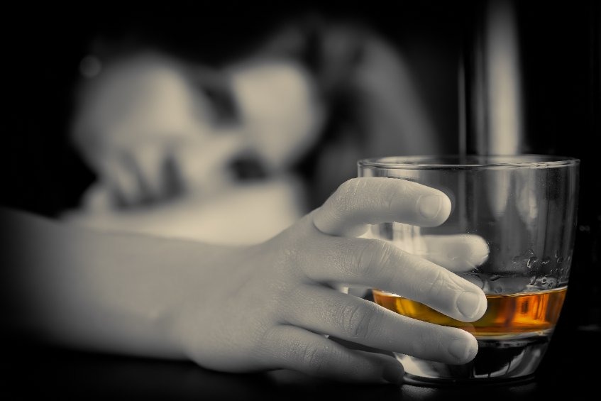 adult with a glass of alcohol with face on a table 