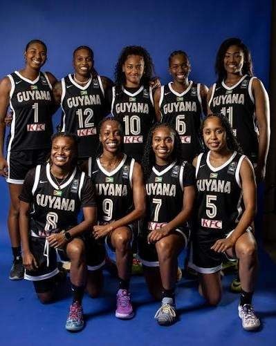 Guyana Senior Women's National Basketball Team squad lined up together on the court in their official black team jerseys
