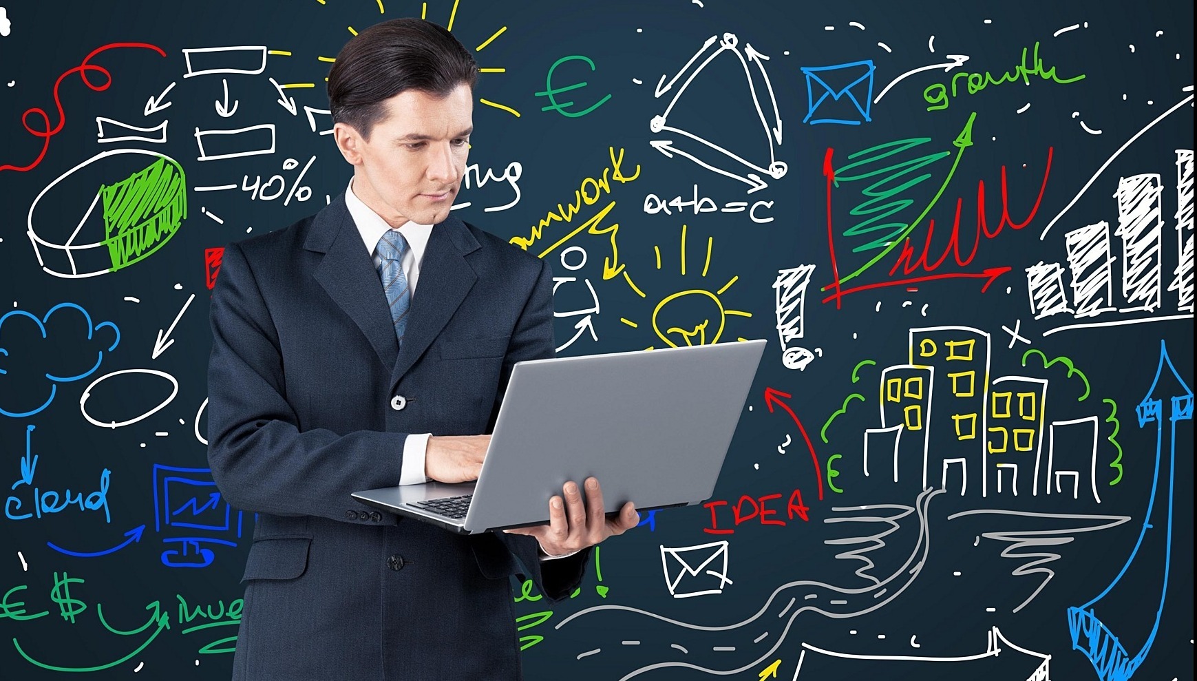 man holding a computer standing in front of a blackboard with numerous illustration on it