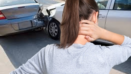 female on street holding neck in pain after auto accident