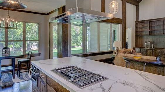 Remodeled kitchen in Las Vegas with modern design, granite top island flowing into dining and living areas, highlighting an open concept design with abundant natural light.