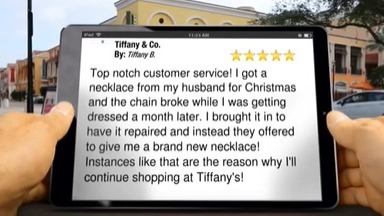 hands holding an iPad viewing a 5 star review for Tiffany & Co..