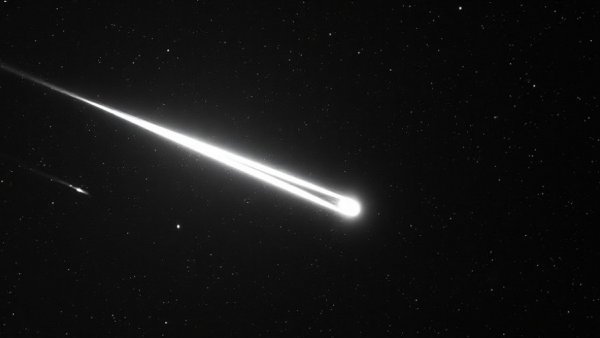 Interstellar comet traversing space with starry backdrop.