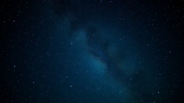 Expansive space scene with scattered stars and galaxies.