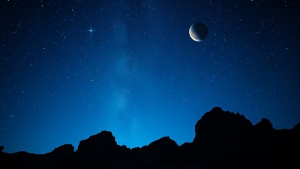 Views of Jupiter and Saturn in a starlit night sky over rocky terrain.