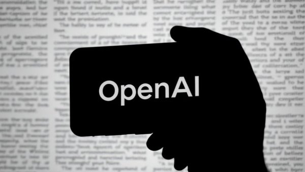 OpenAI logo on smartphone with blurred text background, advertising on ChatGPT.