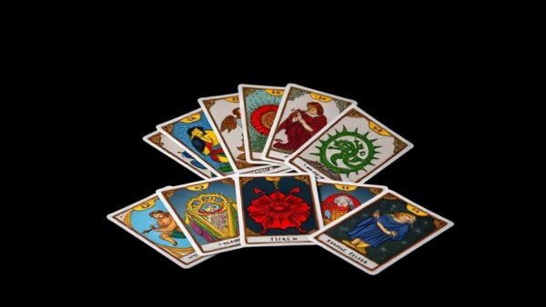 Colorful tarot cards spread on black background.