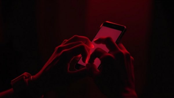 Person using smartphone for Android fake call detection.