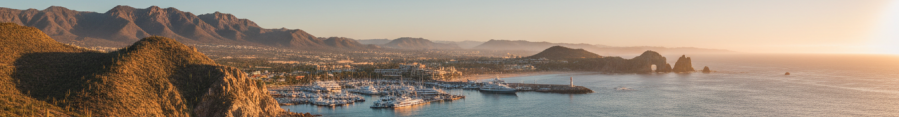 Ultra-realistic panoramic view of Los Cabos coastline at golden hour.