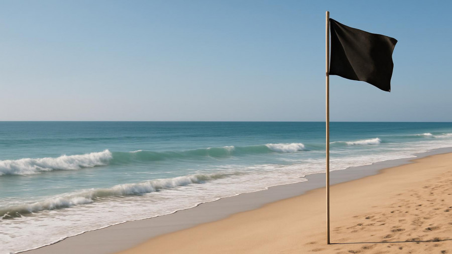 Cabo beach with black flag; hurricane season traveler tips.