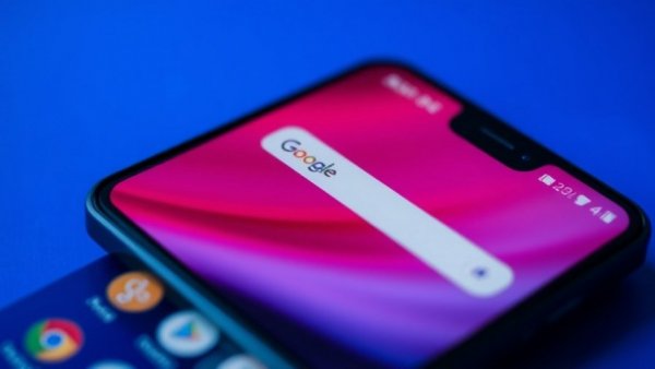 Android smartphone with Google search bar and colorful background.