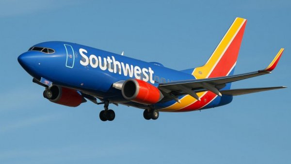 Colorful airplane mid-flight for Los Cabos direct flights.