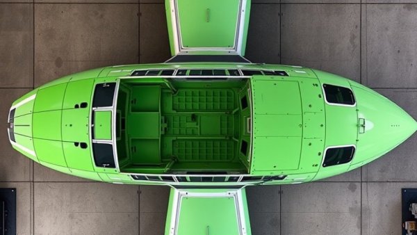 Boeing airplane cockpit in assembly, top view with green panels.