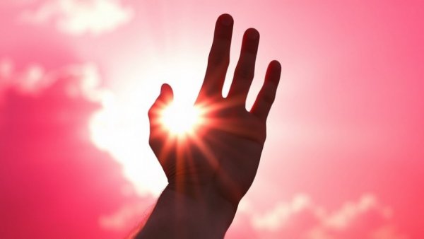 Hand shadow with bright sun and pink sky during upcoming El Niño events.